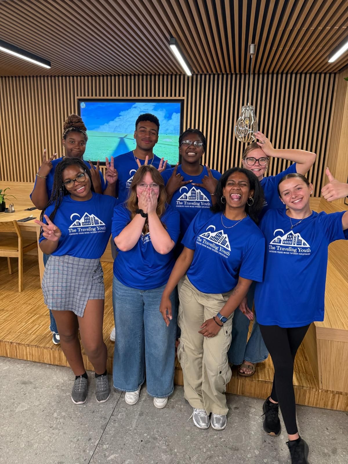 TTY students in blue Traveling Youth shirts celebrating together